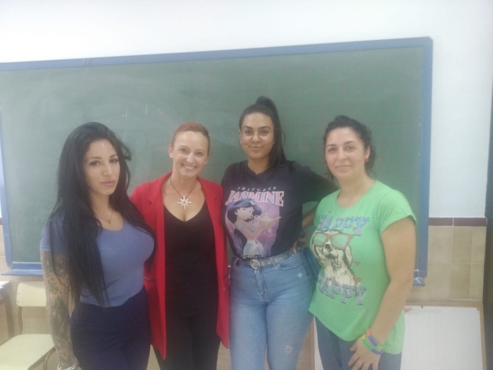 Four smiling women in front of a blackboard