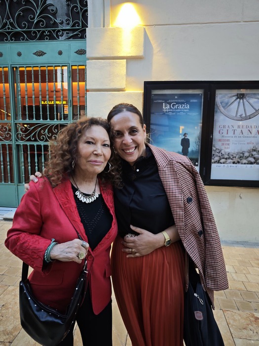 Two smiling women hugging at the «Con voz propia» conference