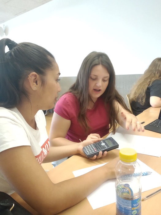 Two girls studying with a calculator