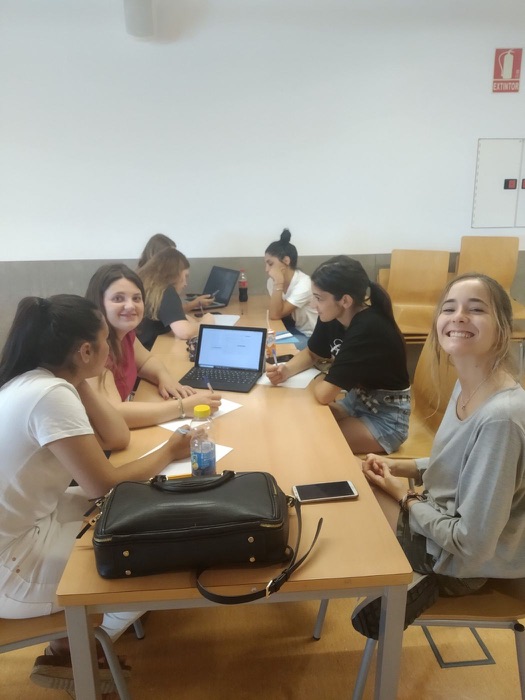 Girls studying around a table with a laptop