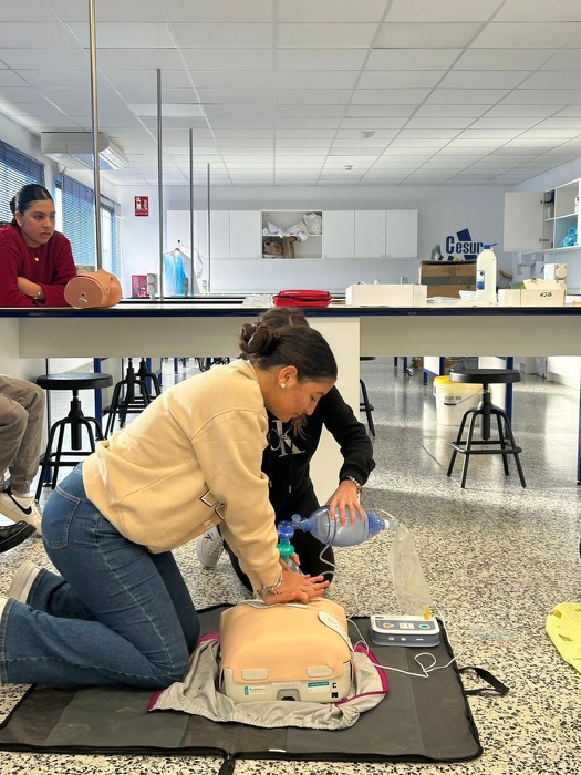 A student practising CPR on a training mannequin