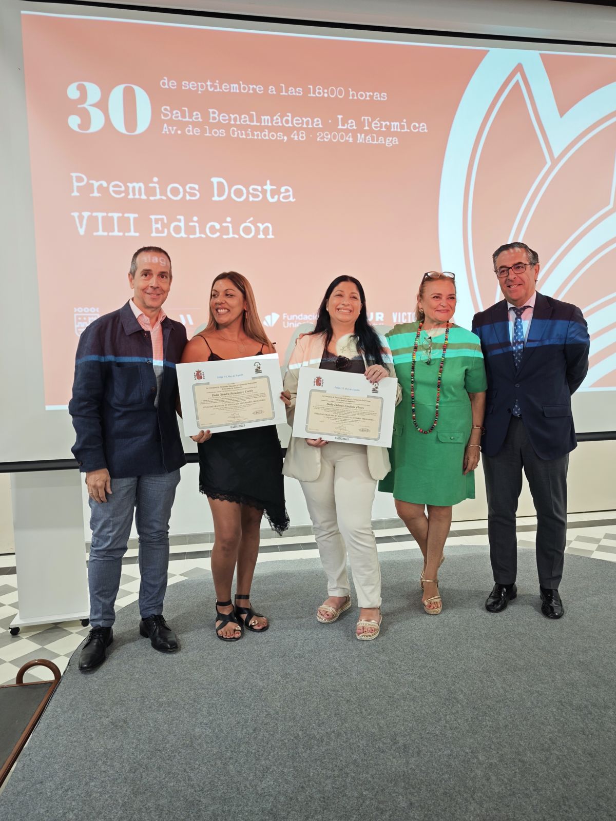 Alumnas con sus diplomas junto a representantes institucionales
